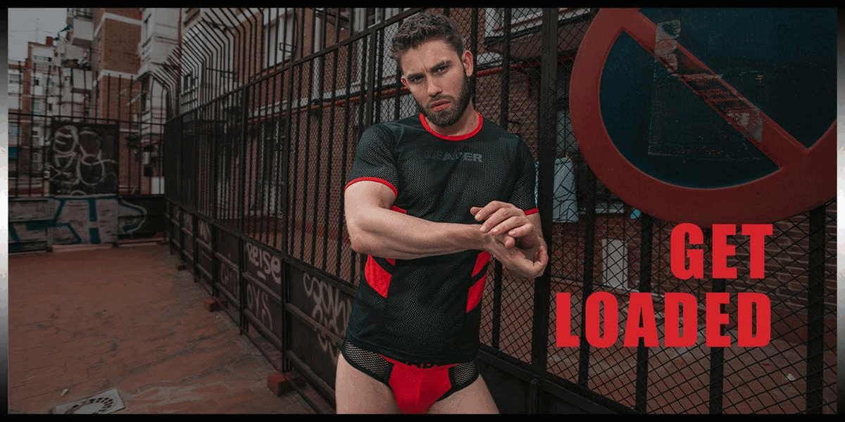 Hot model wearing red and black LOADED T short and briefs in a yard with graffiti